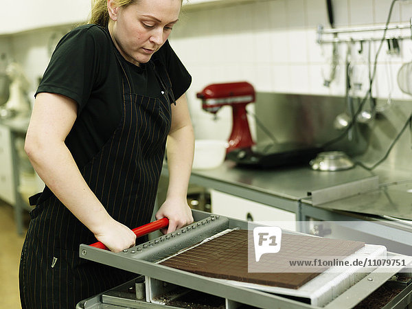 Frau bereitet Schokolade in einer Konditorei zu