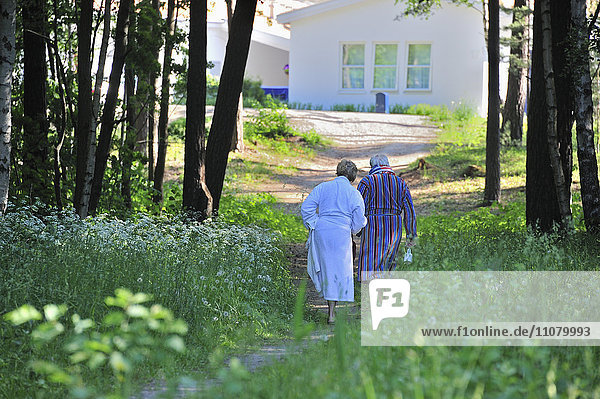 Älteres Paar geht im Gras spazieren