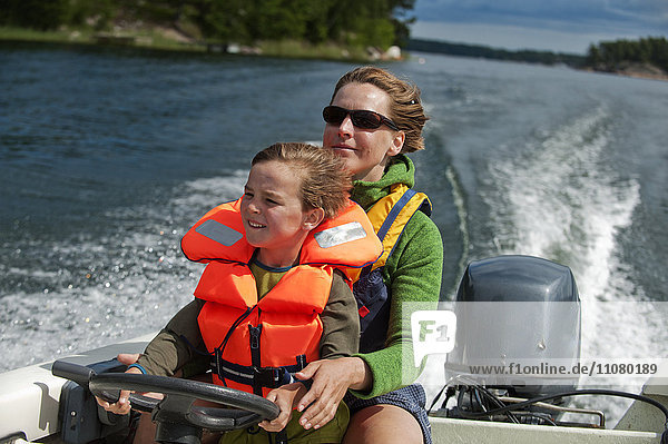 Woman with boy driving a motorboat