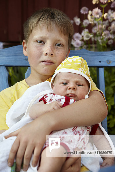 Junge mit neugeborenem Kind  Porträt