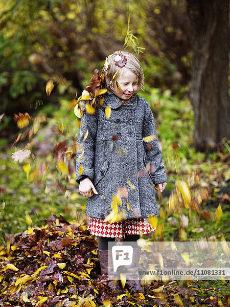 Herbstblätter fallen auf Mädchen
