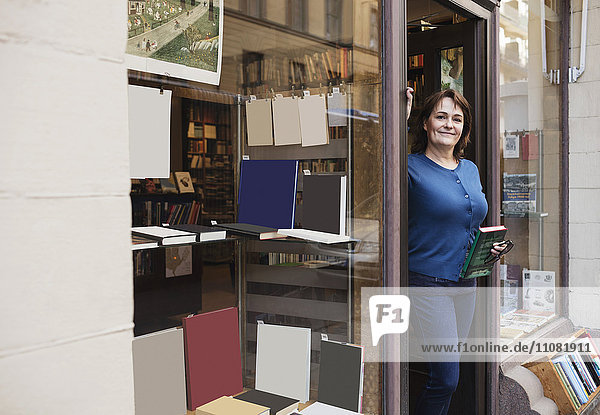 Porträt eines lächelnden Bibliothekars  der vor der Tür steht.