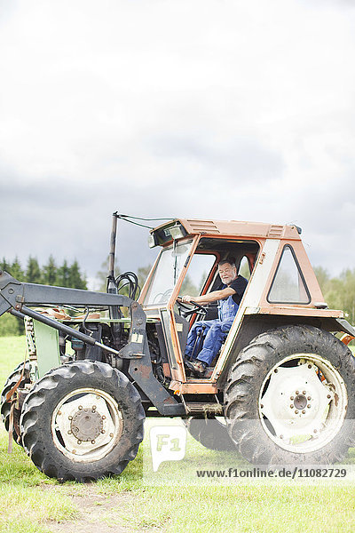 Senior man on tractor Smaland Sweden