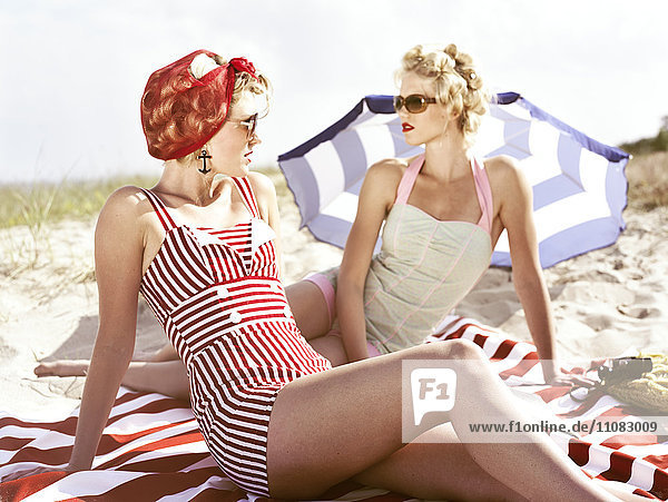 Zwei junge Retro-Frauen am Strand