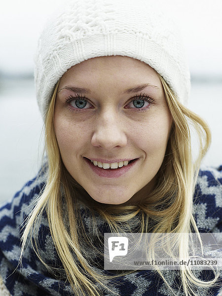 Portrait of young woman wearing muffler and knit hat