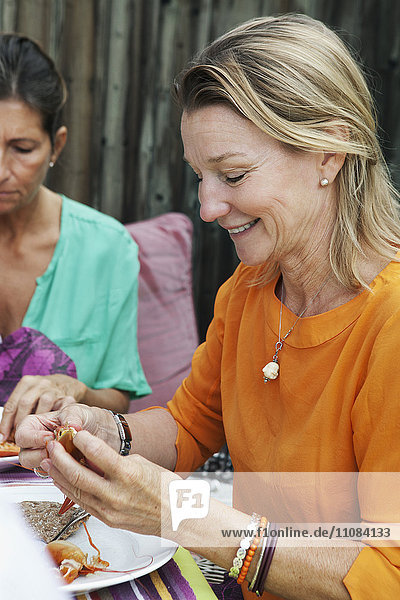 Ältere Frau beim Essen auf einer Flusskrebs-Party  Schweden