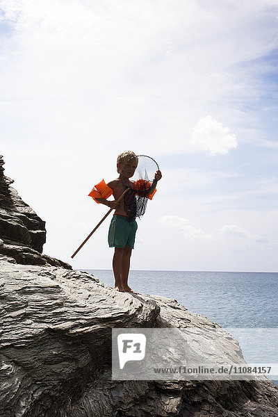 Boy on coast with fishing net  Greece