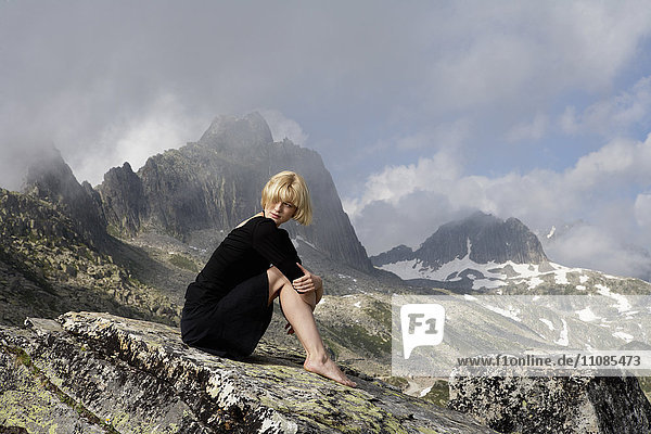 Blond woman wearing a black dress in mountain scenery  Switzerland.