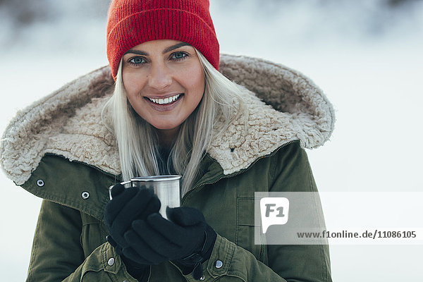 Porträt einer jungen Frau beim Kaffee im Winter