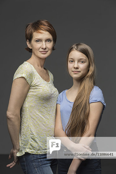 Porträt von Mutter und Tochter vor grauem Hintergrund