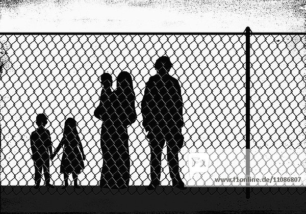 Scherenschnittfamilie vor dem Zaun stehend