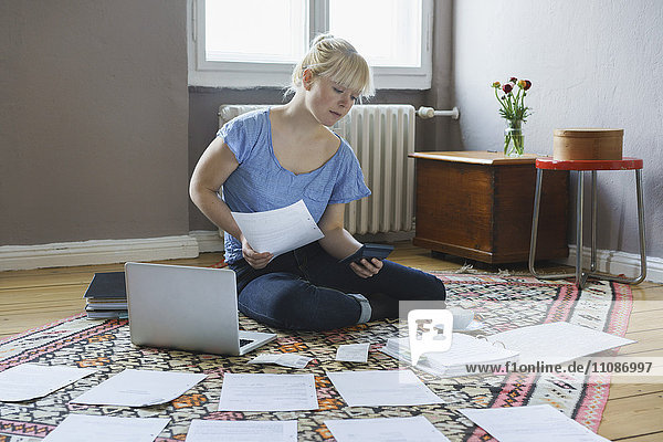 Young woman doing paperwork while sitting at home