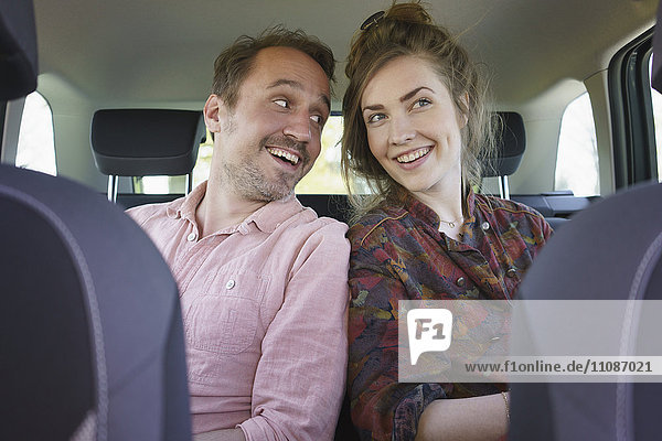 Fröhliches Paar im Auto sitzend