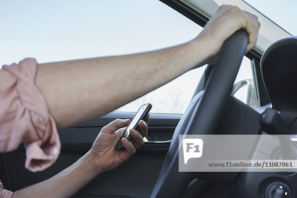 Cropped image of hand using phone while driving car
