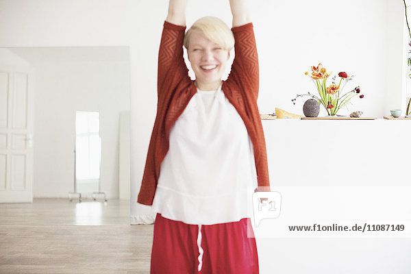 Smiling mid adult woman exercising at home
