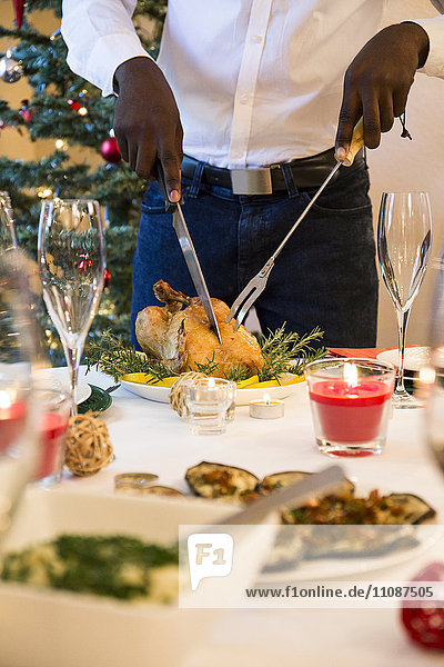 Man carving a roast chicken for Christmas dinner