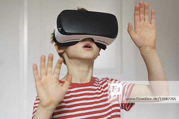 Boy playing virtual reality game at home