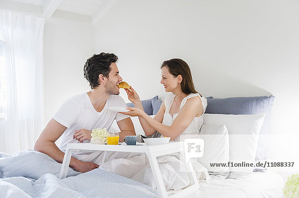 Paar im Bett mit Frühstückstablett