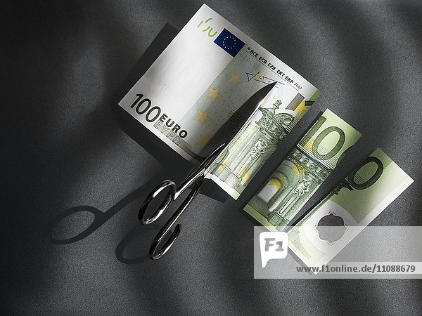 100 euro and scissors  symbolic picture  costs