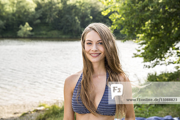 Portrait of smiling young woman at lakeside