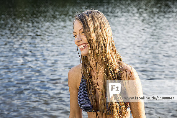 Lachende junge Frau in einem See