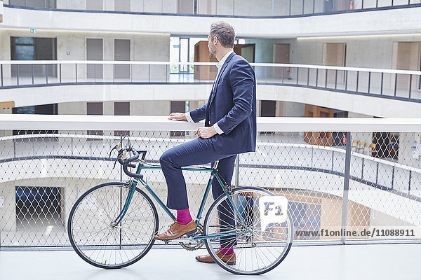 Geschäftsmann mit Fahrrad im modernen Bürogebäude