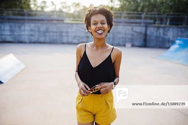 Porträt einer lächelnden jungen Frau im Skatepark