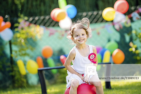 Happy little girl having birthday party in the garden