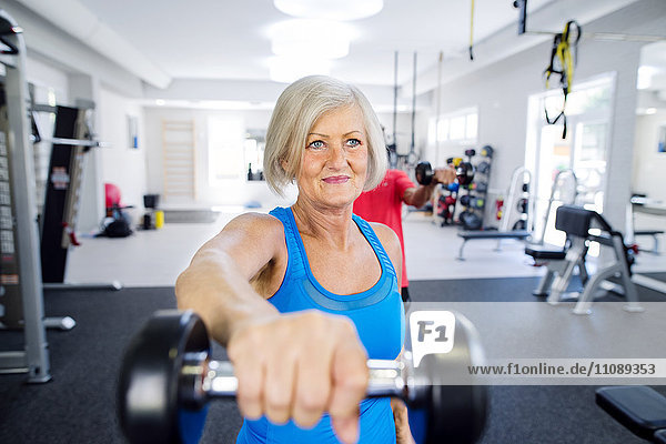 Mature woman working out in fitness gym