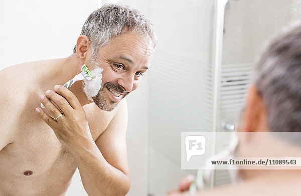 Mirror image of shaving man