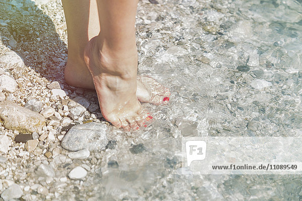 Feet of young woman at water'se dge