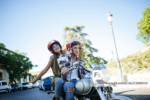 Glückliches junges Paar beim Motorradfahren