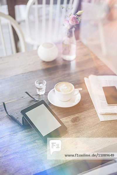 E-Book  Sonnenbrille und Tasse Kaffee auf dem Tisch im Cafe