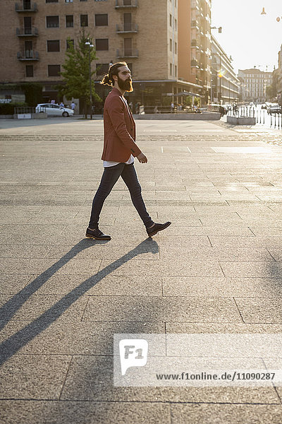 Fashionable young man walking on a square