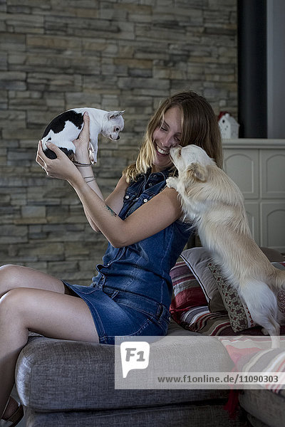 Lächelnde Frau mit ihren Hunden zu Hause