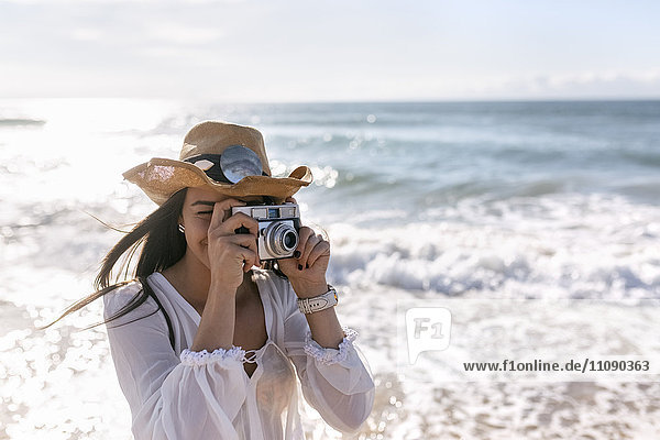 Asturien  Spanien  schöne junge Frau mit Kamera am Strand