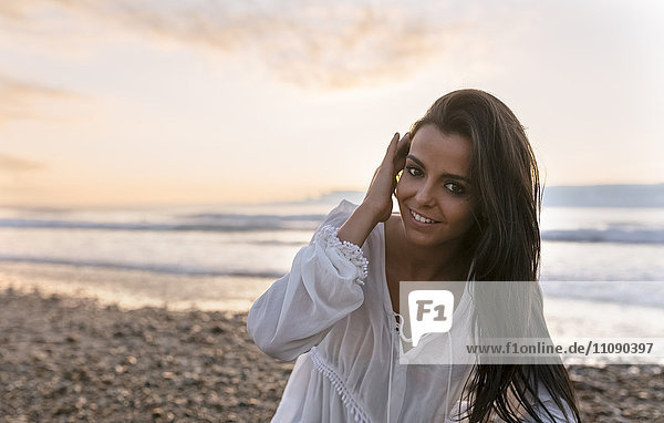 Spain  Asturias  beautiful young woman on the beach at sunset