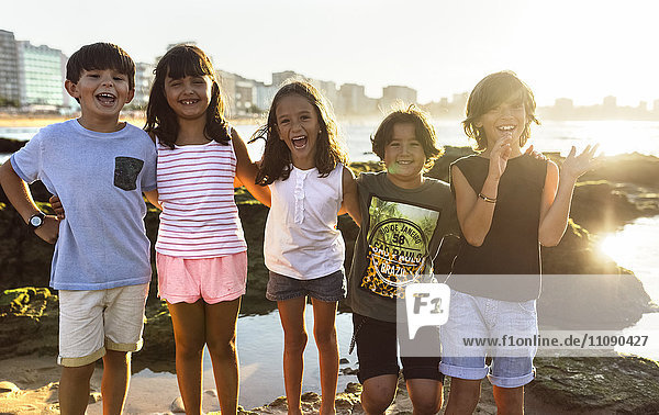 Kindergruppe am Strand bei Sonnenuntergang