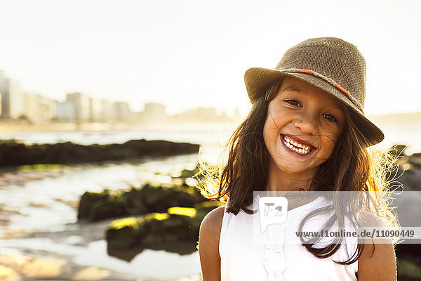 Porträt eines lächelnden Mädchens am Strand bei Sonnenuntergang
