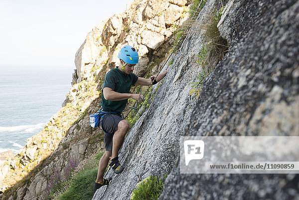 Young man climbing a rock wall