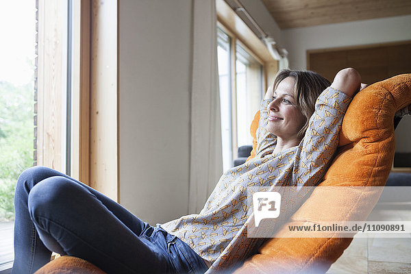 Smiling woman relaxing in armchair