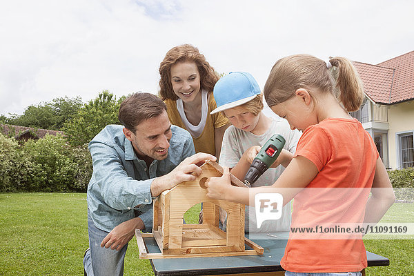 Family building up a birdhouse together