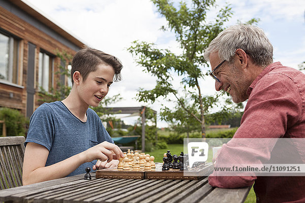 Vater und Sohn beim Schachspielen im Garten