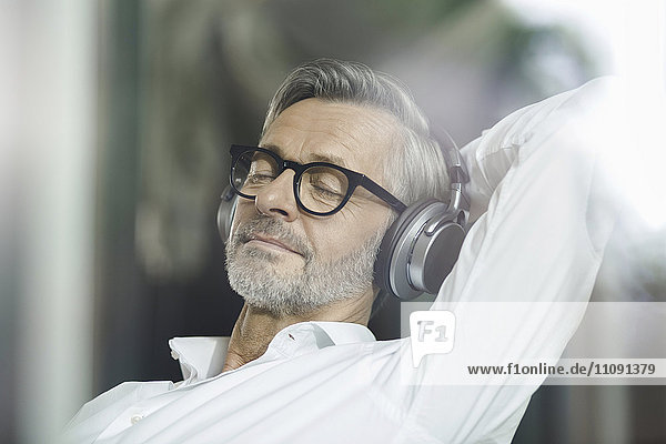 Porträt eines Mannes mit geschlossenen Augen Musik hören mit Kopfhörer