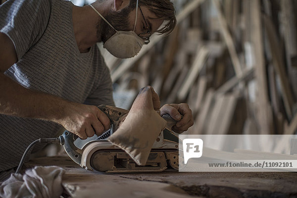 Carpenter using wood sander
