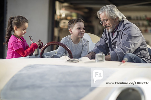 Senior Mann mit Junge und Mädchen in einem Cabriolet zum restaurieren
