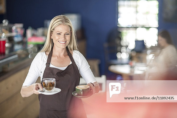 Waitress serving coffee and tea in a cafe