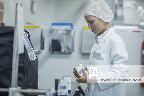 Lab worker in pharmaceutical plant packaging medicine