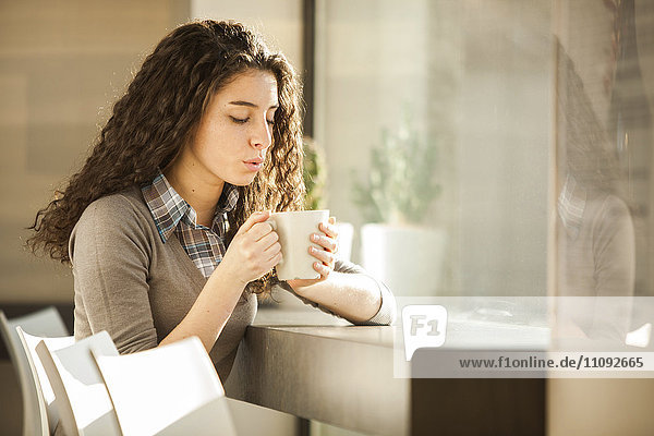 Junge Frau mit Tasse Kaffee im Café