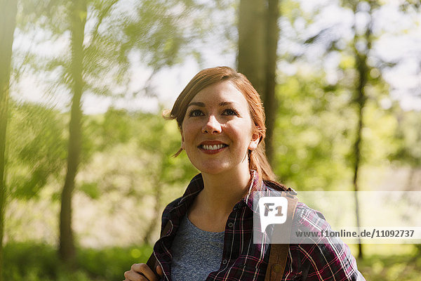 Portrait smiling woman with red hair hiking in woods